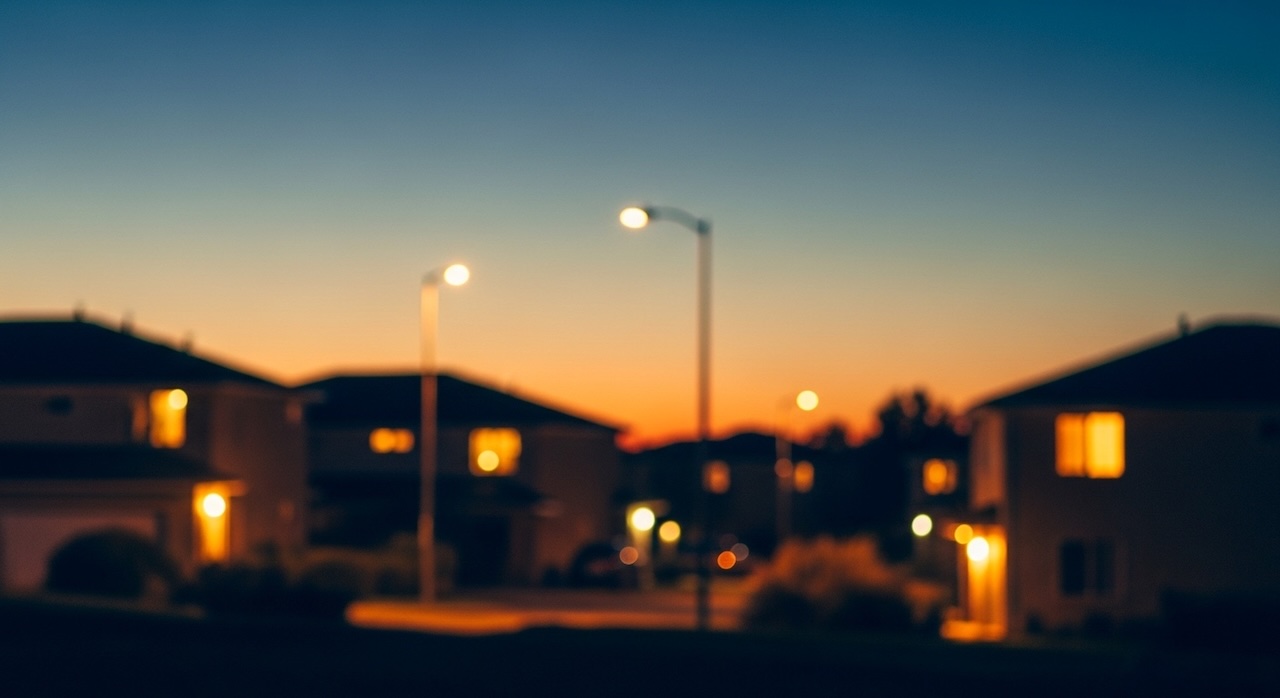 夕暮れに街灯と家の明かりが灯る住宅街